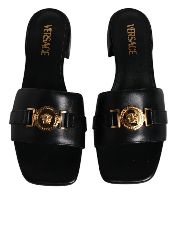 Sandalias planas Versace de cuero negro con placa del logotipo