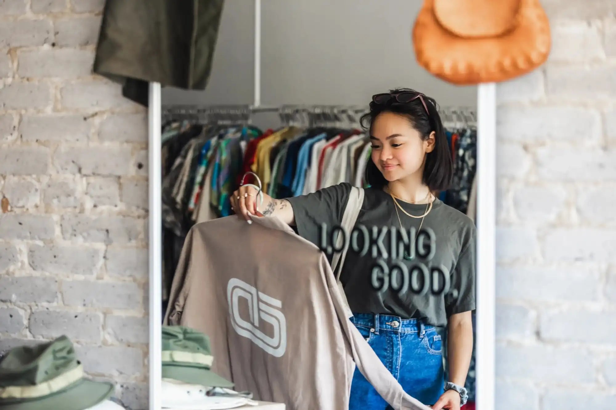 Woman holding a shirt with a logo in a clothing store